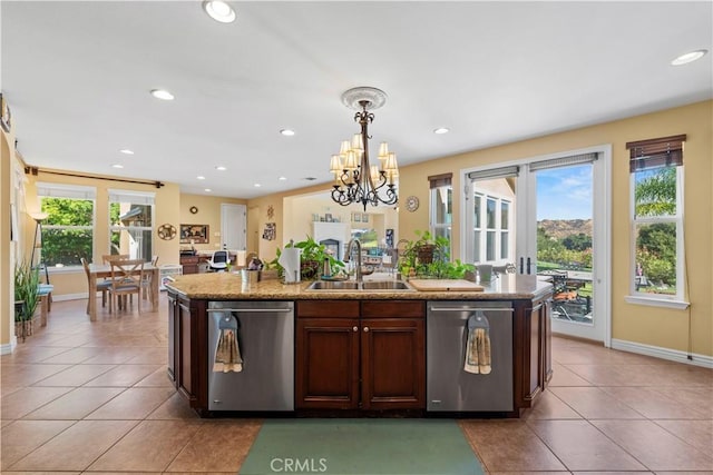 kitchen featuring stainless steel dishwasher, plenty of natural light, pendant lighting, and sink