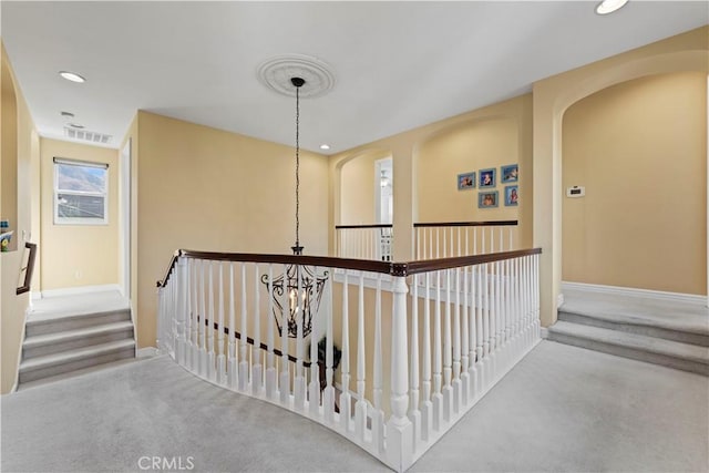 hallway with carpet and a chandelier