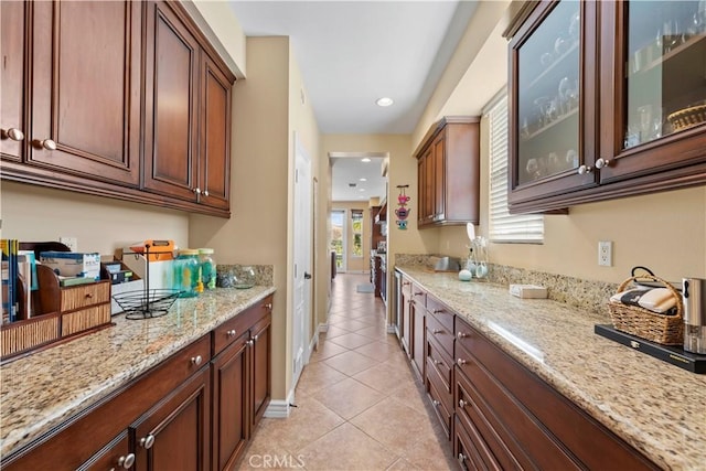 kitchen with light tile patterned flooring and light stone counters