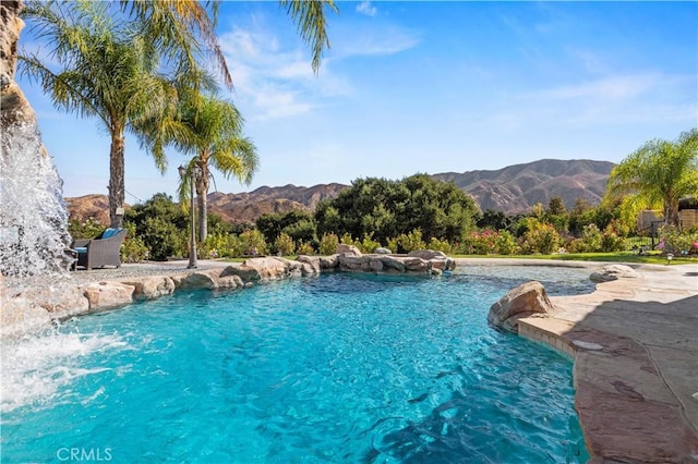 view of pool with pool water feature and a mountain view