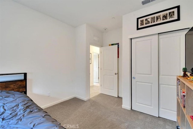 bedroom featuring light carpet and a closet