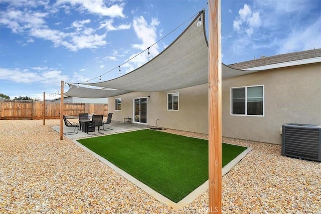 rear view of house featuring a lawn, central AC, and a patio area