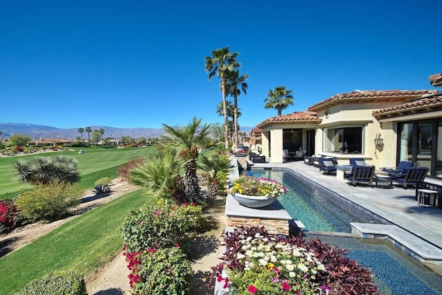 exterior space featuring outdoor lounge area, a mountain view, and a patio