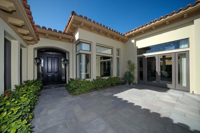 view of exterior entry featuring french doors and a patio