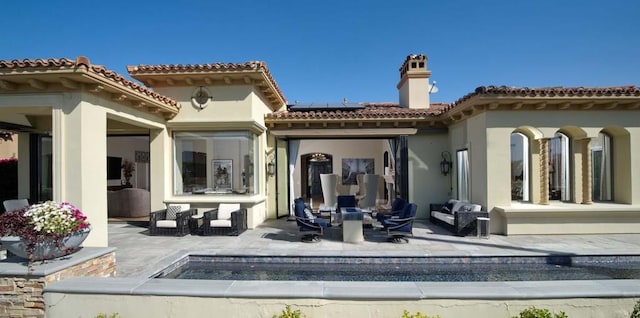 back of house with solar panels and a patio area