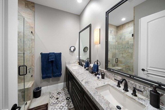 bathroom featuring tile patterned floors, a shower with door, and vanity