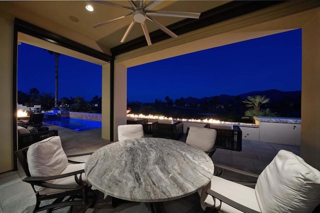 patio at night featuring ceiling fan