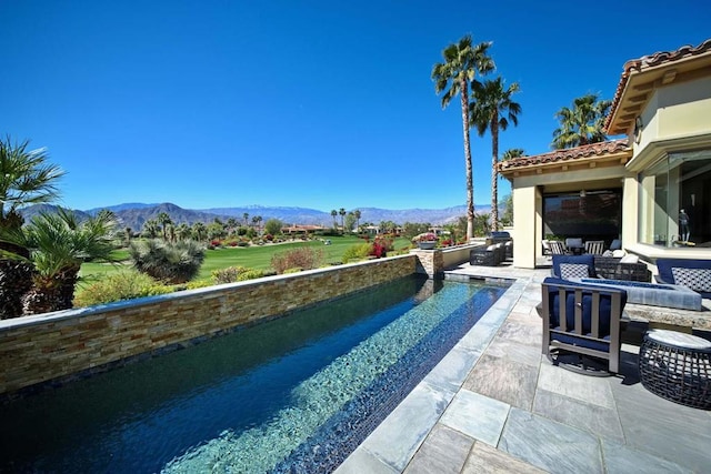 view of swimming pool featuring outdoor lounge area, a mountain view, and a patio