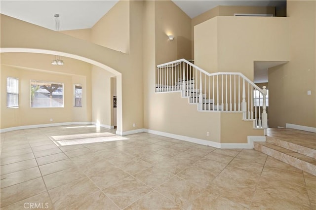 foyer entrance featuring light tile patterned floors and a high ceiling