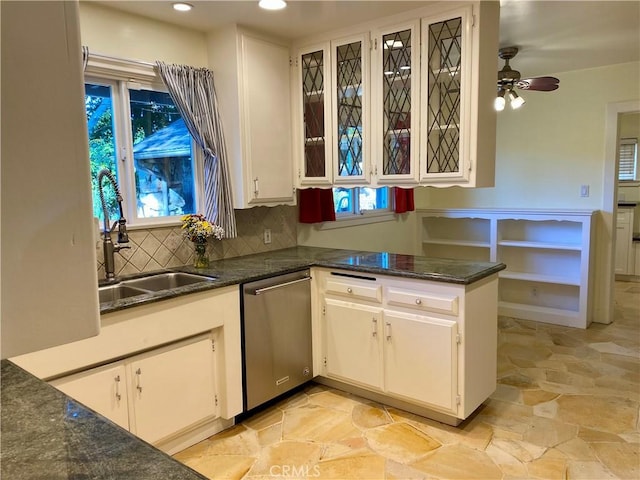 kitchen with decorative backsplash, stainless steel dishwasher, ceiling fan, sink, and white cabinets