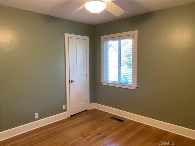 empty room with hardwood / wood-style flooring and ceiling fan