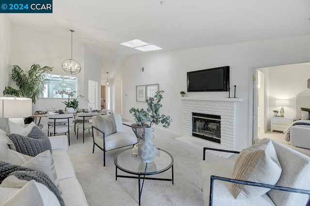 carpeted living room with a brick fireplace, vaulted ceiling, and a notable chandelier