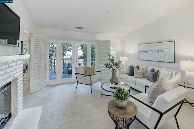 living room with a fireplace, light carpet, vaulted ceiling, and french doors