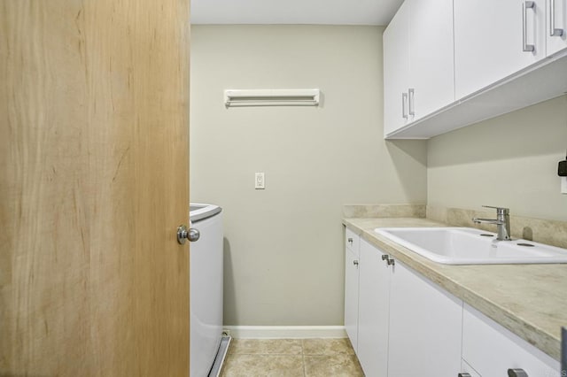 laundry area featuring cabinets, washer / dryer, sink, and light tile patterned floors