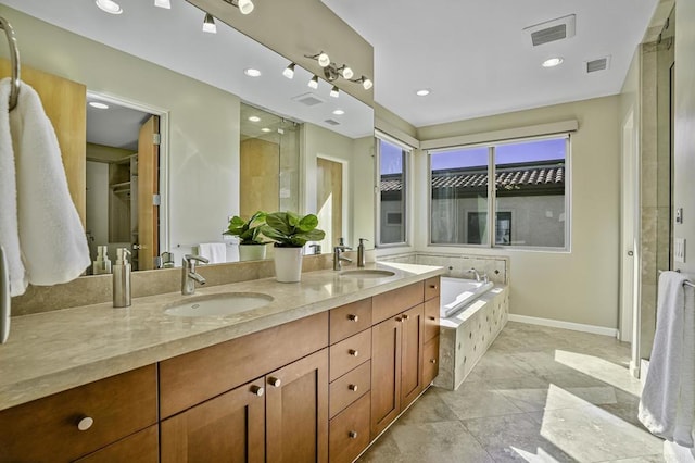 full bathroom with double vanity, a garden tub, visible vents, and a sink