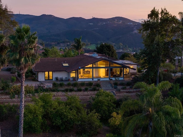 back house at dusk with a mountain view