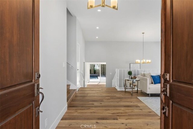 foyer entrance featuring hardwood / wood-style floors and a notable chandelier