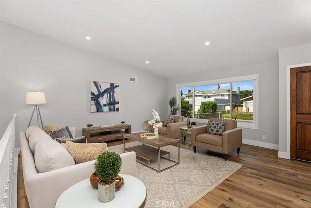 living room featuring hardwood / wood-style floors and lofted ceiling