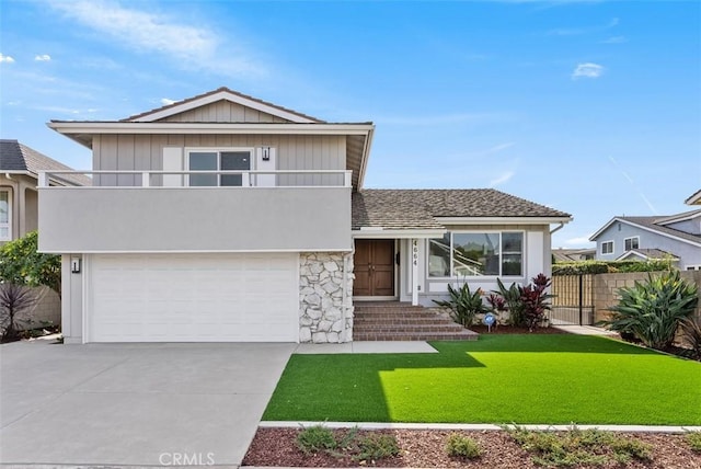 view of front of home featuring a garage, a balcony, and a front lawn