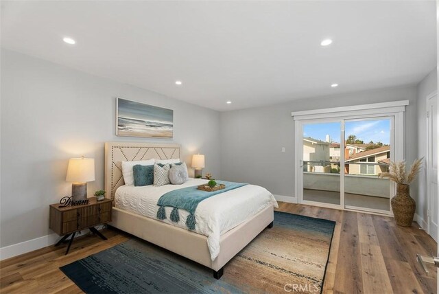 bedroom with access to outside and hardwood / wood-style floors