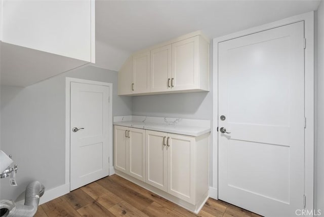 laundry room with cabinets and light hardwood / wood-style flooring