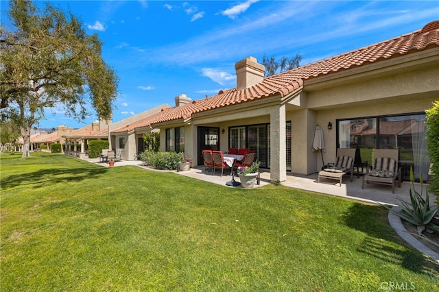 back of house featuring a patio and a lawn