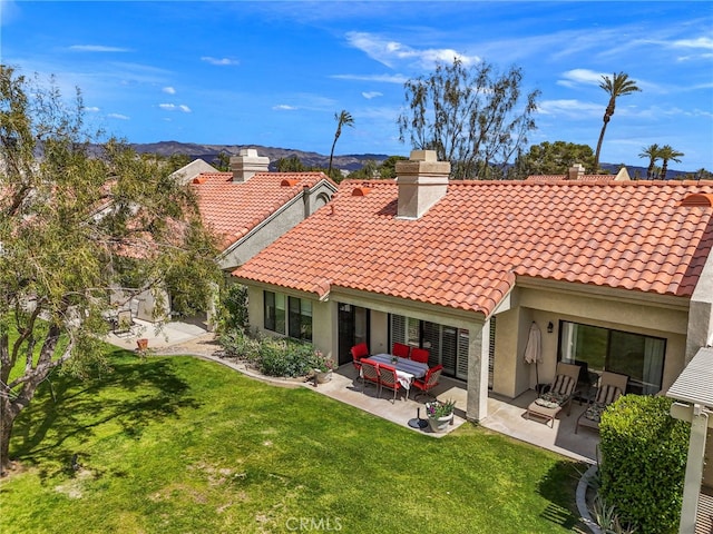 back of house with a yard and a patio