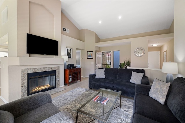 living room with high vaulted ceiling and light hardwood / wood-style flooring