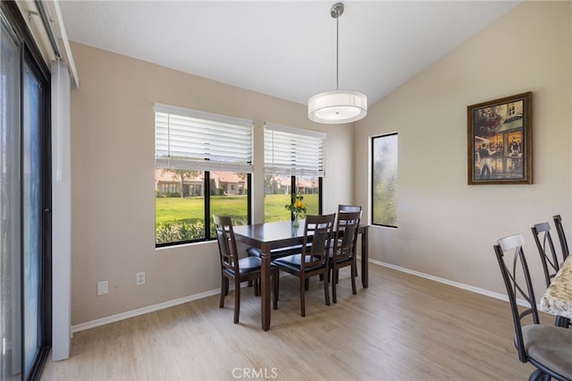 dining area featuring light hardwood / wood-style floors and vaulted ceiling