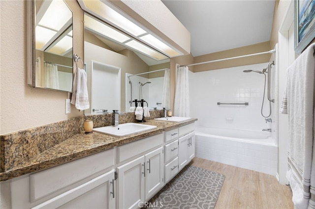 bathroom featuring hardwood / wood-style floors, vanity, and shower / tub combo