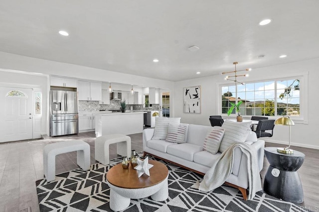 living room featuring light wood-type flooring and a notable chandelier