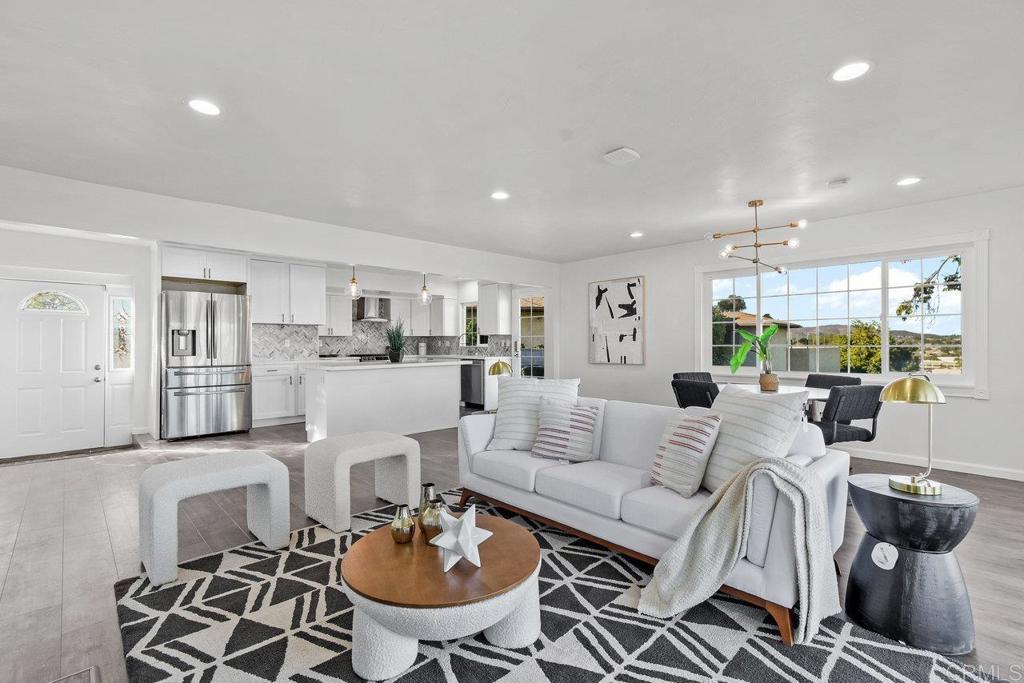 living area with a notable chandelier, baseboards, wood finished floors, and recessed lighting