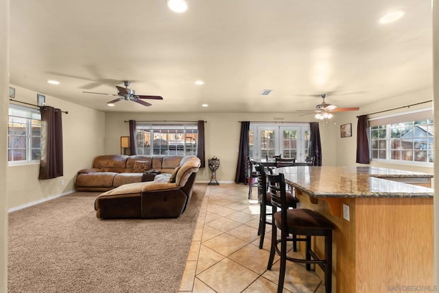 living room with ceiling fan, french doors, plenty of natural light, and light tile patterned flooring