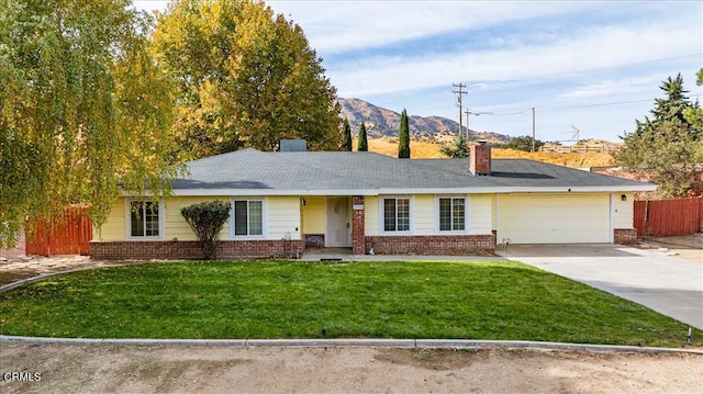 ranch-style house with a mountain view, a garage, and a front lawn