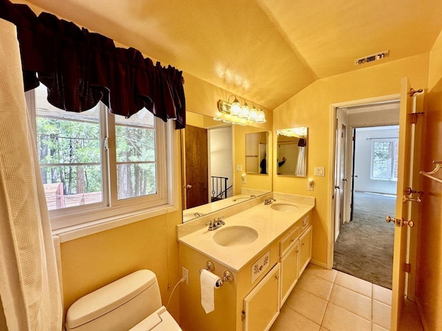 bathroom with tile patterned floors, vanity, lofted ceiling, and toilet