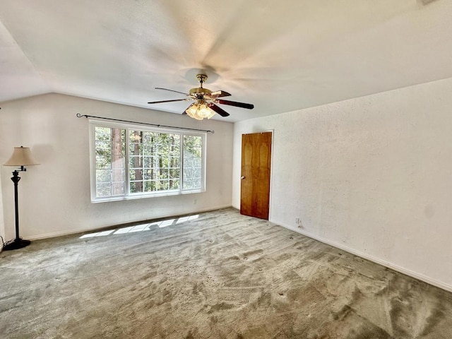 carpeted spare room with ceiling fan and lofted ceiling