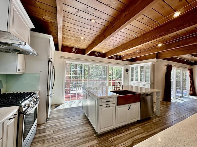 kitchen with a wealth of natural light, white cabinets, wooden ceiling, and appliances with stainless steel finishes