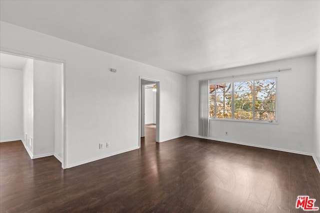 unfurnished room featuring ceiling fan and dark wood-type flooring