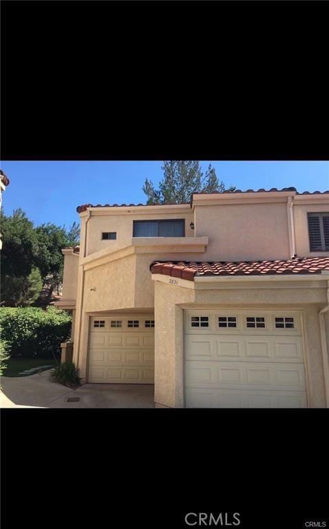 mediterranean / spanish-style house with a garage