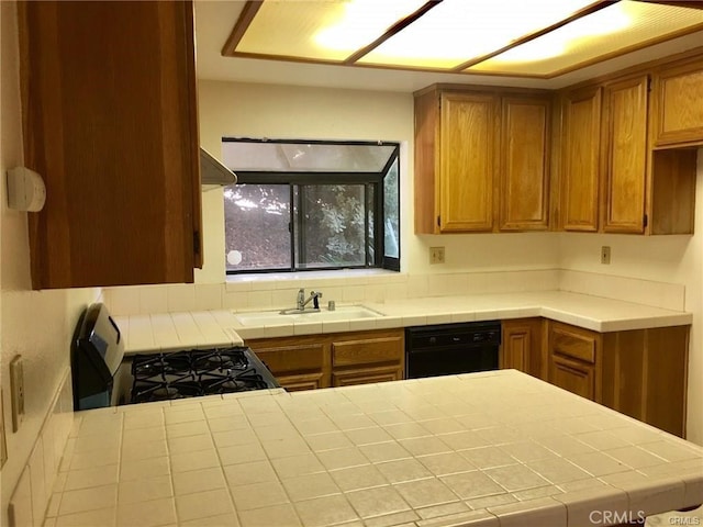 kitchen with tile counters, sink, black dishwasher, and gas range