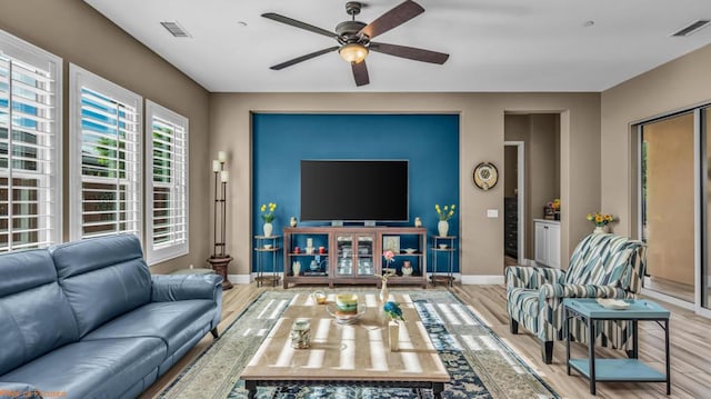 living room with light hardwood / wood-style flooring and ceiling fan