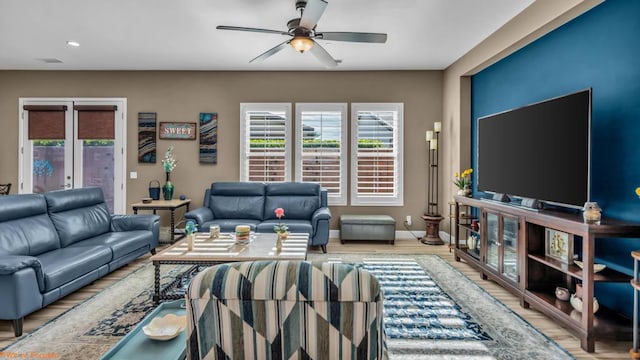 living room featuring french doors, light wood-type flooring, and ceiling fan