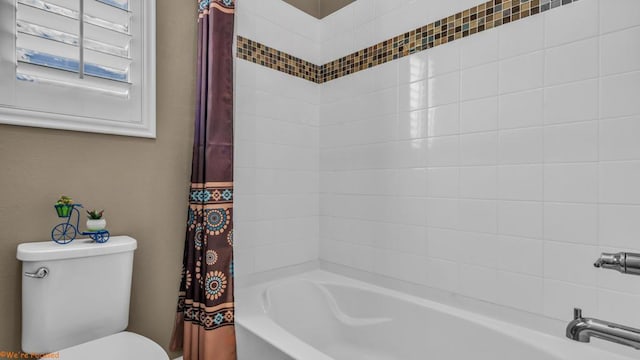 bathroom featuring shower / tub combo with curtain and toilet