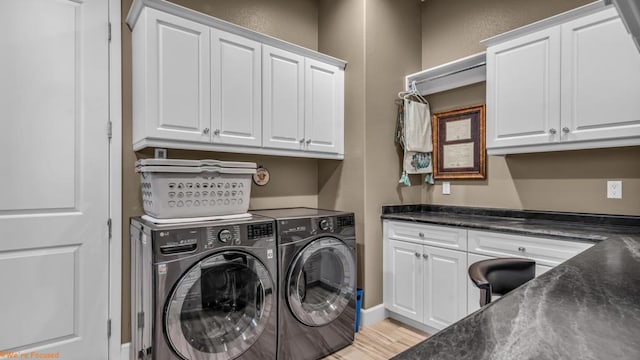 washroom featuring cabinets, light hardwood / wood-style floors, and washing machine and dryer