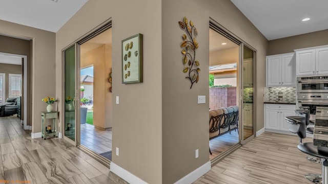 hallway with light hardwood / wood-style floors