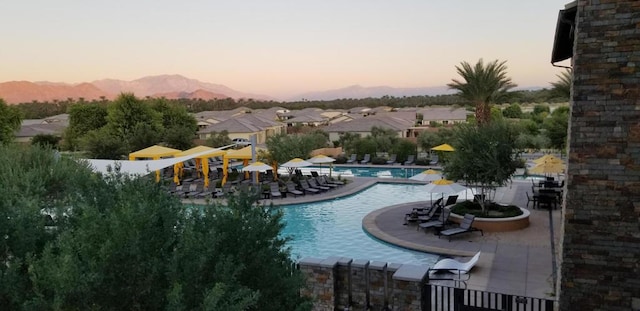 pool at dusk featuring a patio