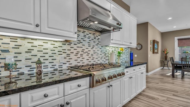 kitchen featuring white cabinetry, wall chimney exhaust hood, light wood-type flooring, and stainless steel gas stovetop