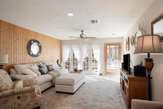 living room with ceiling fan and wooden walls