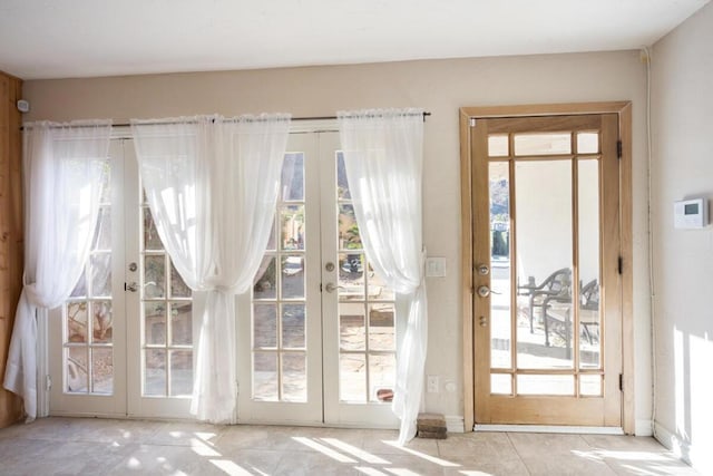 entryway featuring light tile patterned floors and french doors