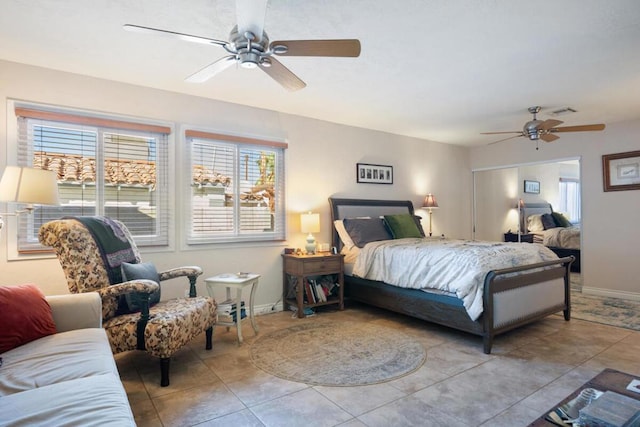 tiled bedroom featuring ceiling fan and multiple windows